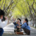 BEIJING, Seorang wanita mengabadikan foto anak-anak bermain dengan dedaunan yang berguguran di sebuah taman di Distrik Jiangdu, Yangzhou, Provinsi Jiangsu, China timur, pada 18 November 2023. (Xinhua/Meng Delong)