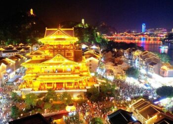Foto yang diabadikan menggunakan drone ini menunjukkan orang-orang mengunjungi kota kuno Yaobu di Liuzhou, Daerah Otonom Etnis Zhuang Guangxi, China selatan, pada 3 Mei 2025. (Xinhua/Huang Xiaobang)