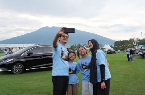 Satu keluarga berfoto dengan mobil BYD M6 dalam acara perayaan satu tahun peluncuran M6 yang berlangsung di Sukabumi, Provinsi Jawa Barat, pada Sabtu (14/6). (Sumber: PT BYD Motor Indonesia)