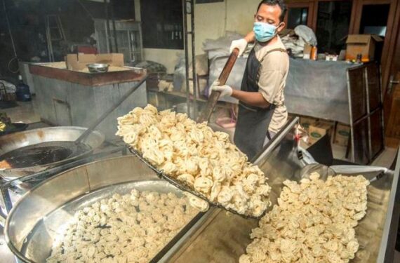 Seorang pekerja memindahkan kerupuk ikan dari wajan untuk ditiriskan minyaknya di sebuah pabrik rumahan di Maguwoharjo, Kabupaten Sleman, Daerah Istimewa Yogyakarta, pada 18 Juni 2025. (Xinhua/ Agung Supriyanto)