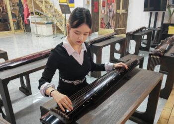 Foto yang diabadikan pada 27 Mei 2025 ini menunjukkan Shinta Devi Suryani (kiri), seorang mahasiswi Indonesia yang sedang menuntut ilmu di China, menjajal Guqin, alat musik tradisional China, di Provinsi Shanxi, China utara. (Xinhua)