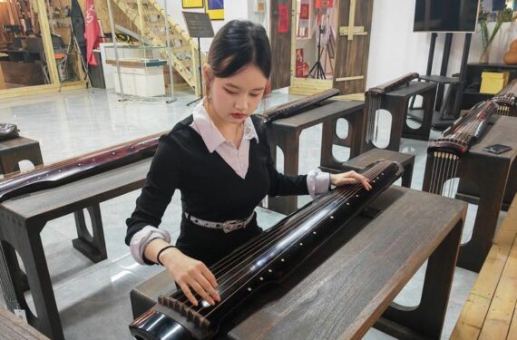 Foto yang diabadikan pada 27 Mei 2025 ini menunjukkan Shinta Devi Suryani (kiri), seorang mahasiswi Indonesia yang sedang menuntut ilmu di China, menjajal Guqin, alat musik tradisional China, di Provinsi Shanxi, China utara. (Xinhua)