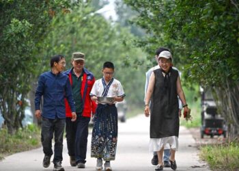 Seorang anak dan keluarganya berjalan ke sebuah ladang untuk memetik tomat di Perkebunan Huiai di Yangliuqing, Distrik Xiqing, Tianjin, China utara, pada 31 Mei 2025. (Xinhua/Zhao Zishuo)