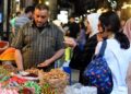 (250605) -- DAMASCUS, June 5, 2025 (Xinhua) -- A shopkeeper communicates with customers at his stall in a bustling market ahead of the Eid al-Adha in Damascus, Syria, on June 5, 2025. (Photo by Ammar Safarjalani/Xinhua)