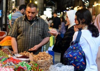 (250605) -- DAMASCUS, June 5, 2025 (Xinhua) -- A shopkeeper communicates with customers at his stall in a bustling market ahead of the Eid al-Adha in Damascus, Syria, on June 5, 2025. (Photo by Ammar Safarjalani/Xinhua)
