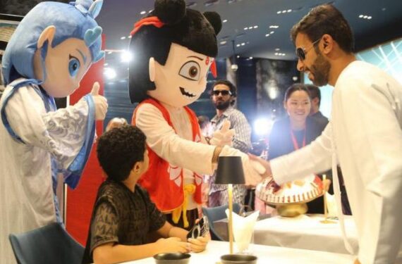 Seorang pria berjabat tangan dengan karakter berkostum Ne Zha saat pemutaran perdana film animasi China "Ne Zha 2" di Dubai, Uni Emirat Arab (UEA), pada 15 Juli 2025. (Xinhua/Wen Xinnian)