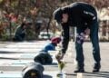 Seorang pria meletakkan bunga di monumen peringatan salah satu korban Penembakan Lewiston di Lewiston, Maine, Amerika Serikat, pada 25 Oktober 2024. (Xinhua/Ziyu Julian Zhu)