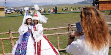 (250805) -- YINING, Aug. 5, 2025 (Xinhua) -- Tourists pose for photos in traditional costumes at Narat scenic area in Xinyuan County of Ili Kazak Autonomous Prefecture, northwest China's Xinjiang Uygur Autonomous Region, Aug. 3, 2025. Ili Kazak Autonomous Prefecture has ushered in its peak tourism period. The region's unique natural landscapes and cultural sites have attracted a large number of visitors. It received 54.93 million domestic tourists in the first seven months of this year, a year-on-year increase of 10.31 percent. (Xinhua/Zhao Yusi)