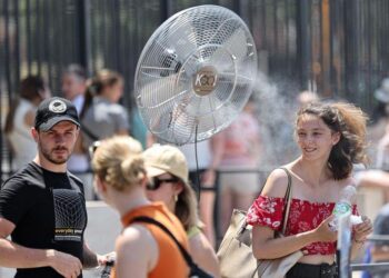 Para wisatawan mendinginkan diri di depan kipas angin di dekat Colosseum di Roma, Italia, pada 27 Juni 2025. (Xinhua/Li Jing)